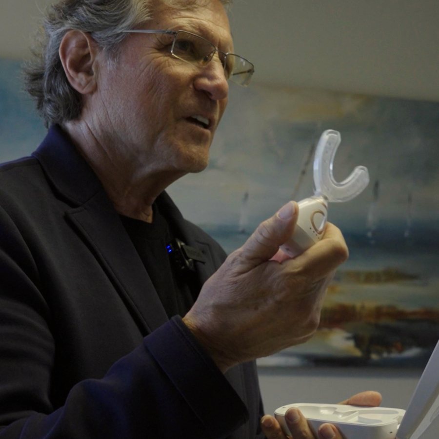 A brand partner presenting a device to the room